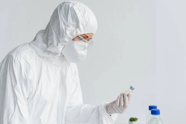 Вчений у костюмі ризику, що тримає вакцину в лабораторії — стокове фото