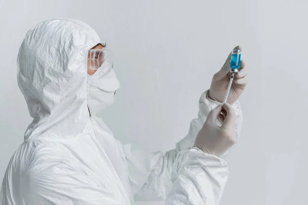Scientist picking up vaccine form jar in syringe — Stock Photo