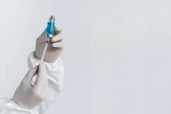 Обрізаний вид вченого в латексних рукавичках, що тримає вакцину та шприц — стокове фото
