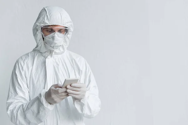 Вчений у костюмі з туману використовує смартфон біля стіни — стокове фото