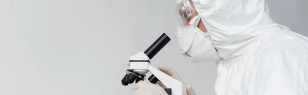 Scientist in protective uniform using microscope, banner — Stock Photo