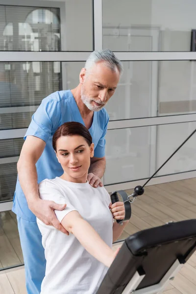 Reife Rehabilitologin unterstützt Frauenausbildung in Reha-Zentrum — Stockfoto