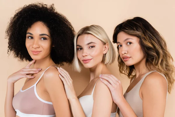 Jeunes femmes interracial en sous-vêtements posant sur beige — Photo de stock