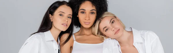 African american woman in bra near friends in white shirts isolated on grey, banner — Stock Photo