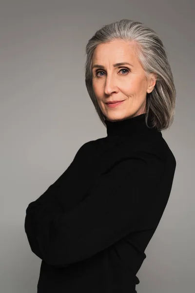 Портрет зрілої жінки в чорному хрустці, ізольований на сірому — стокове фото