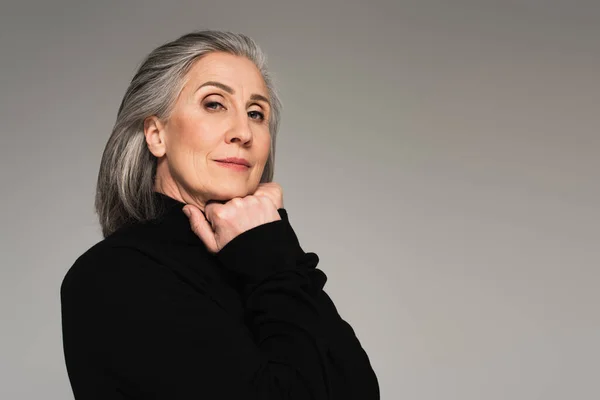 Portrait of mature woman in turtleneck isolated on grey — Stock Photo