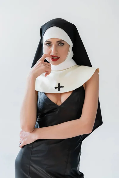 Seductive nun touching lips while looking at camera isolated on grey — Stock Photo