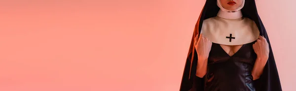 Cropped view of young nun in sexy dress on pink background, banner — Stock Photo