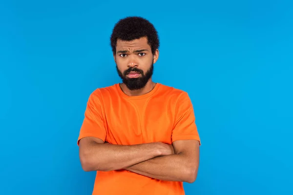 Bearded african american man standing with crossed arms isolated on blue — Stock Photo