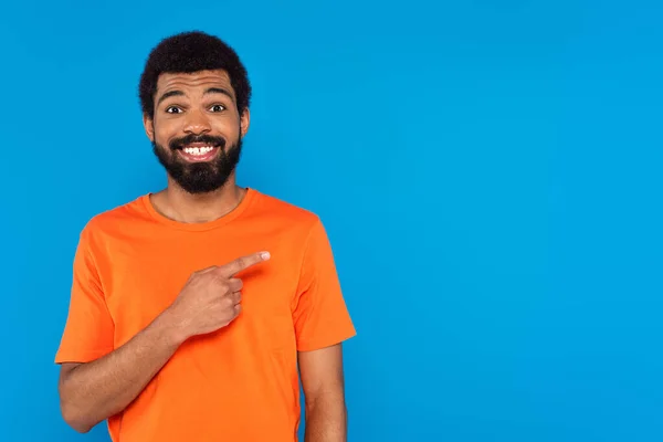 Lächelnder afrikanisch-amerikanischer Mann zeigt mit dem Finger isoliert auf blau — Stockfoto