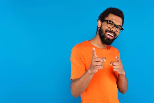 Glücklicher afrikanisch-amerikanischer Mann mit Brille, der isoliert auf blau auf die Kamera zeigt — Stockfoto