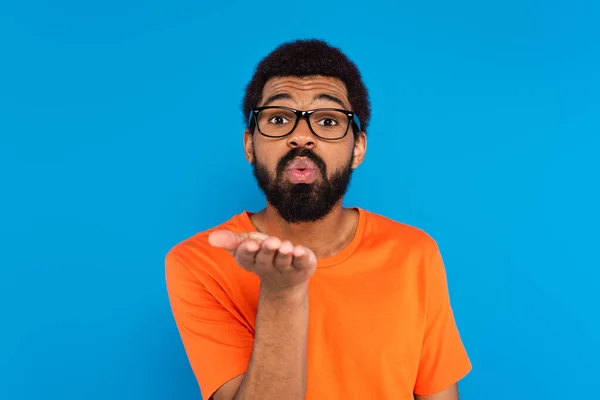 Afrikanisch-amerikanischer Mann in Brille bläst Luftkuss isoliert auf blau — Stockfoto