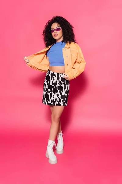 Longitud completa de la mujer afroamericana de moda en gafas de sol posando en rosa — Stock Photo