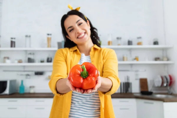 Blurred and happy young woman holding red bell pepper — Stock Photo