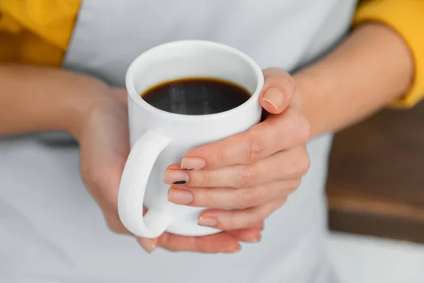 Обрезанный вид женщины, держащей белую чашку кофе — стоковое фото