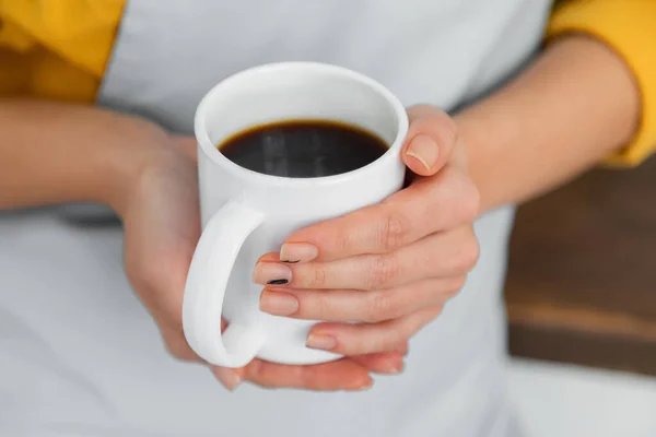 Vista cortada da mulher segurando xícara branca de café — Fotografia de Stock