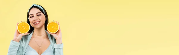 Donna allegra con metà di arancia fresca sorridente alla macchina fotografica isolata su giallo, banner — Foto stock