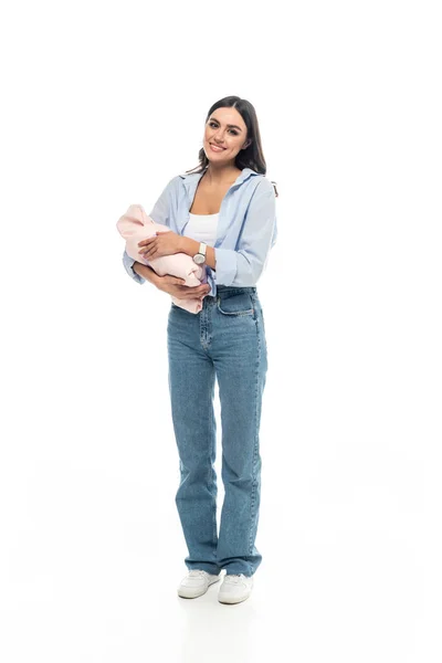 Vue pleine longueur de la jeune femme avec le nouveau-né souriant à la caméra sur fond blanc — Photo de stock