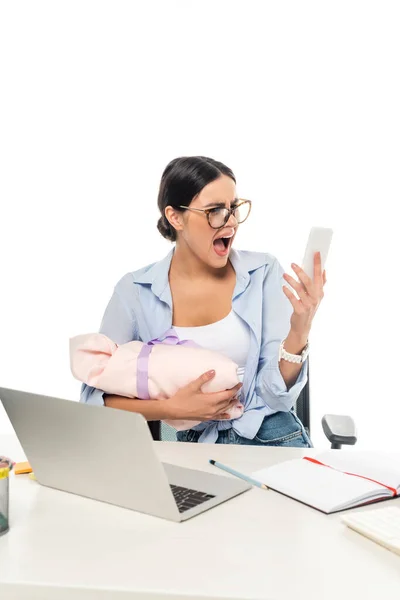 Femme d'affaires irritée crier tout en tenant smartphone et bébé sur le lieu de travail isolé sur blanc — Photo de stock