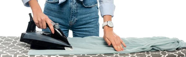 Vista recortada de la mujer en jeans planchar ropa aislada en blanco, bandera - foto de stock