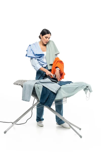 Full length view of tired housewife ironing clothes on white background — Stock Photo