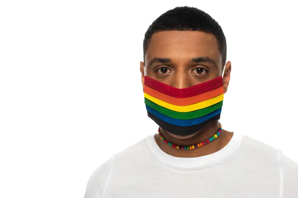 African american man in medical mask and beads in rainbow colors isolated on white, lgbt concept — Stock Photo