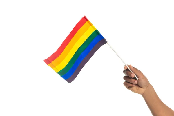 Vista parcial del hombre afroamericano sosteniendo una pequeña bandera lgbt aislada en blanco — Stock Photo