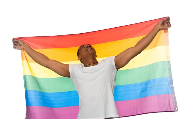 Emocionado hombre afroamericano mirando hacia arriba mientras sostiene la bandera lgbt aislado en blanco - foto de stock