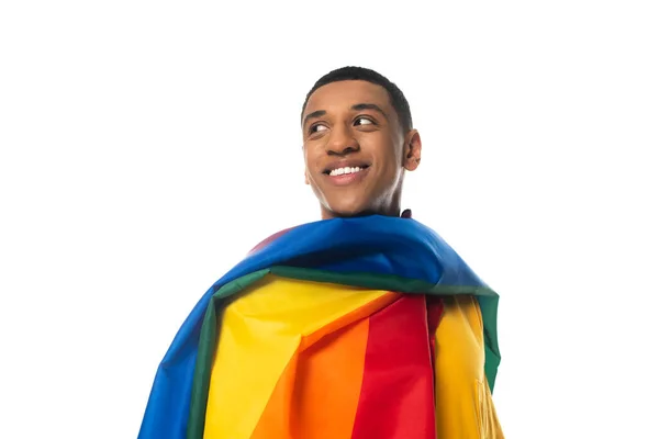 Feliz homem americano africano, coberto com bandeira lgbt, olhando para longe isolado no branco — Fotografia de Stock