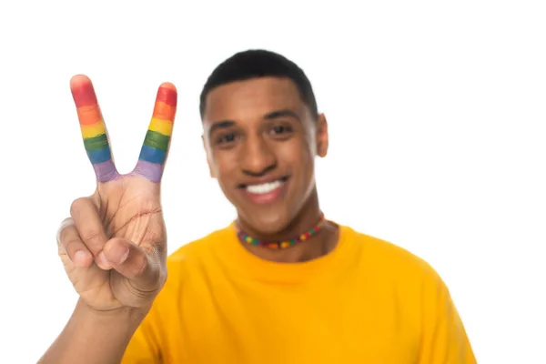 Joyeux homme afro-américain montrant signe de paix avec les doigts peints en couleurs lgbt isolé sur fond blanc, flou — Photo de stock