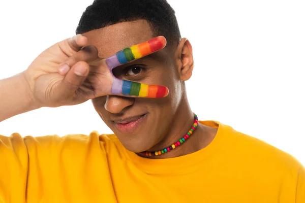 Homme afro-américain montrant signe de victoire avec les doigts peints en couleurs lgbt isolé sur blanc — Photo de stock