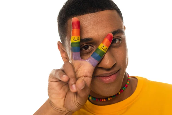 Homme afro-américain avec collier et doigts dans des couleurs lgbt montrant signe de paix isolé sur blanc — Photo de stock