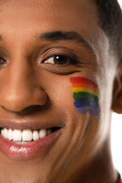 Крупним планом вид усміхненого афроамериканця з прапором lgbt намальований на обличчі ізольований на білому — стокове фото