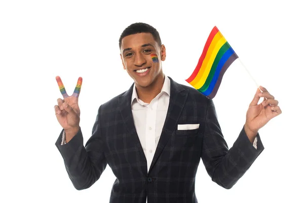 Cheerful african american businessman showing victory gesture while holding lgbt flag isolated on white — Stock Photo