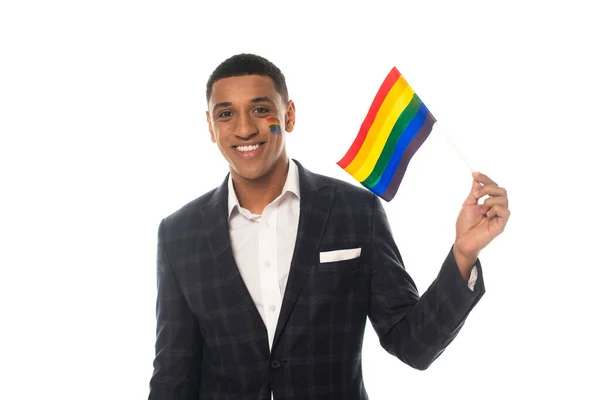 Young african american businessman smiling at camera while holding lgbt flag isolated on white — Stock Photo