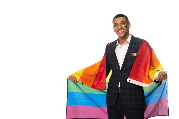 Щасливий афроамериканський бізнесмен тримає прапор lgbt, посміхаючись на камеру ізольовано на білому — стокове фото