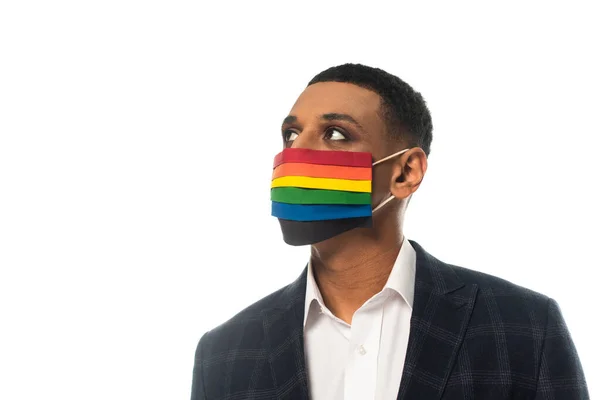 Американський бізнесмен-афроамериканець, одягнений у медичну маску в яскравих кольорах і озираючись усамітнено на білому — стокове фото