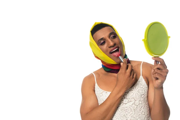 Afro americano transgender uomo in abito e lgbt colori testa fazzoletto applicando rossetto isolato su bianco — Foto stock