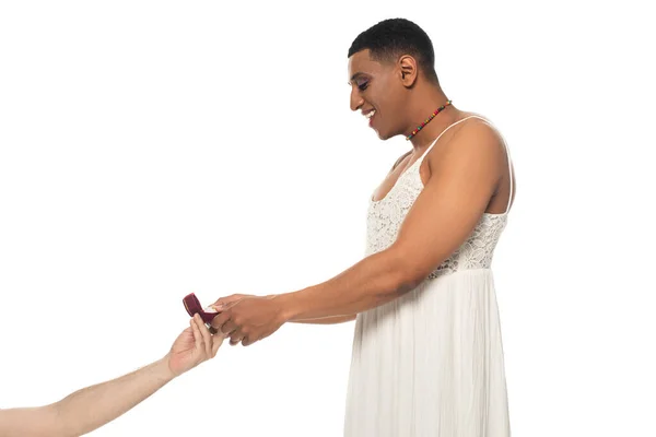 Happy african american transgender taking wedding ring from man isolated on white — Stock Photo