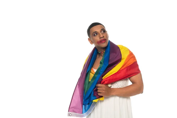 Africano americano transgender uomo, avvolto in lgbt bandiera, guardando lontano isolato su bianco — Foto stock