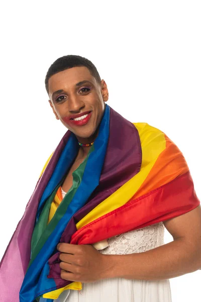 Alegre afroamericano transgénero hombre con maquillaje, cubierto con bandera lgbt aislado en blanco - foto de stock