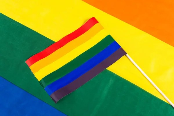 Vue du haut du petit drapeau lgbt sur fond de couleurs arc-en-ciel — Photo de stock