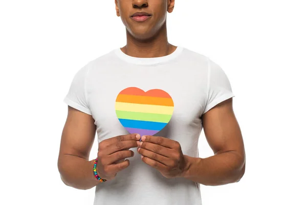 Vue recadrée de l'homme afro-américain avec bracelet et coeur en papier dans des couleurs lgbt isolé sur blanc — Photo de stock