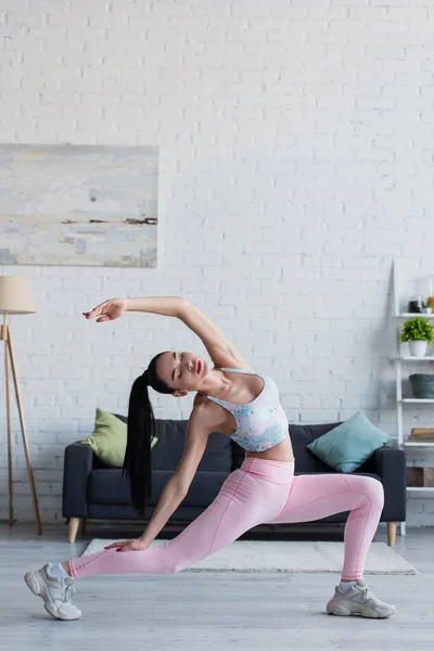 Young woman standing in reverse warrior pose with closed eyes — Stock Photo