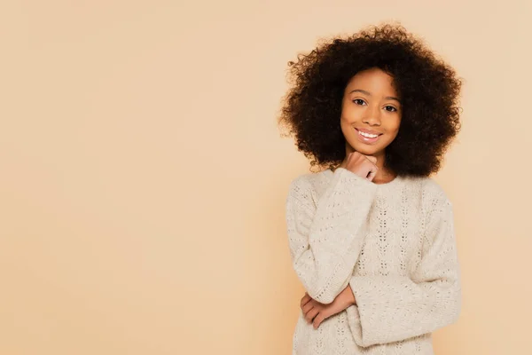 Sonriente preadolescente afroamericano chica con la mano cerca de la cara aislado en beige - foto de stock