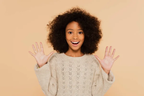 Emocionado afroamericano preadolescente chica con las manos arriba mostrando palmas aisladas en beige - foto de stock