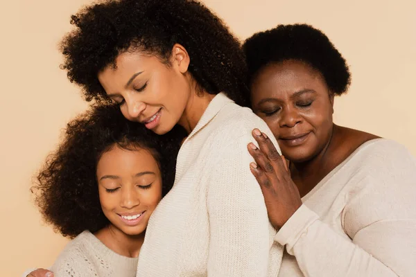 Afro-américaine grand-mère embrasser avec fille et petite-fille avec les yeux fermés isolé sur beige — Photo de stock