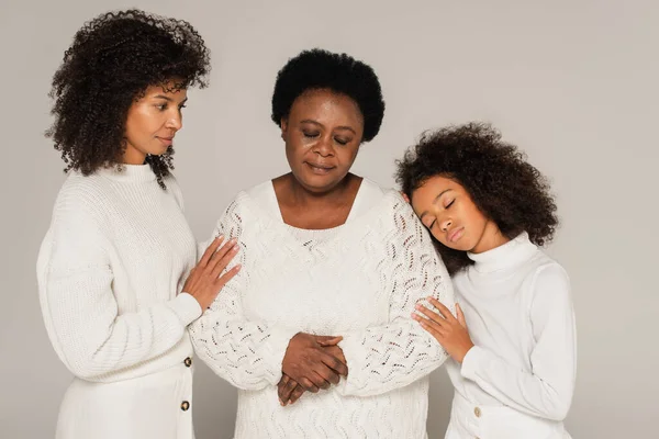 Сумна афроамериканська дочка, мати і бабуся стоять ізольовані на сірому — стокове фото