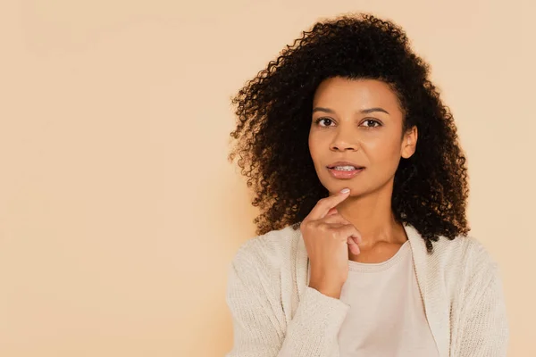 Femme américaine africaine réfléchie avec la main près du visage isolé sur beige — Photo de stock