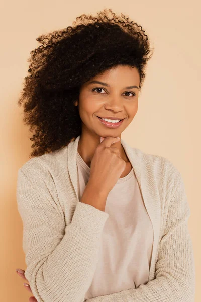 Mujer afroamericana con la mano cerca de la cara aislada en beige - foto de stock